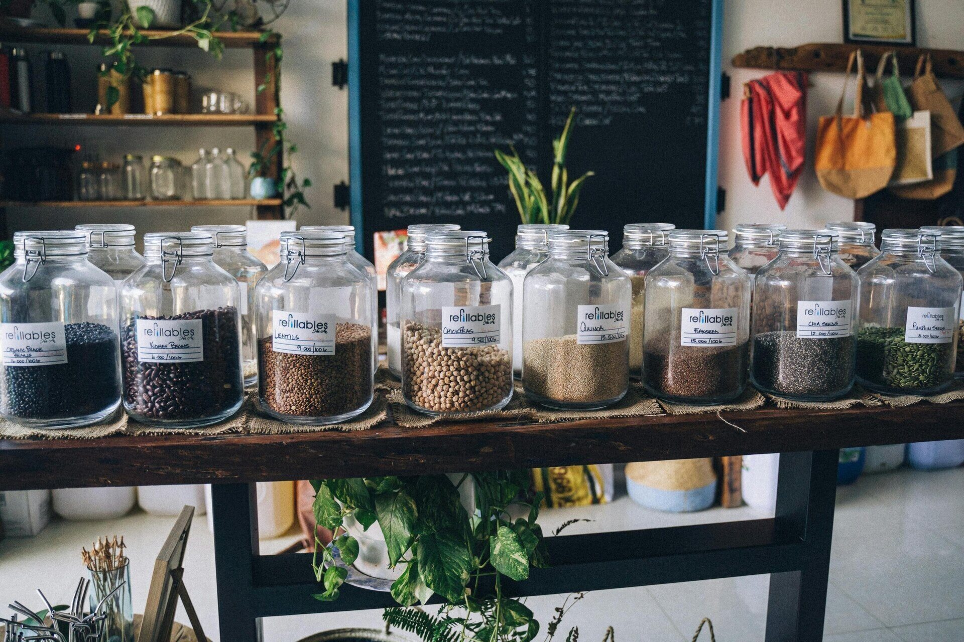 Shelf of labeled glass apothecary jars filled with dried herbs and seeds